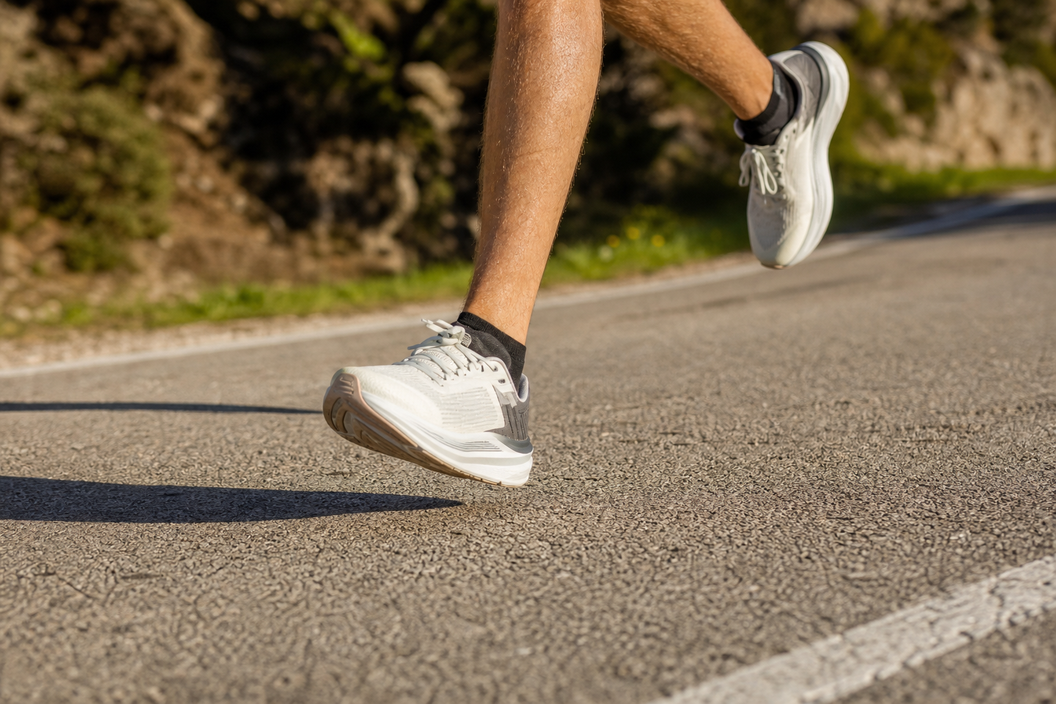Coureur en extérieur portant des chaussures de running amorties, gros plan sur la foulée
