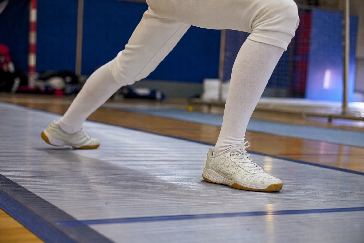 Chaussures de sport en salle adaptées aux appuis latéraux, posées sur un sol de gymnase