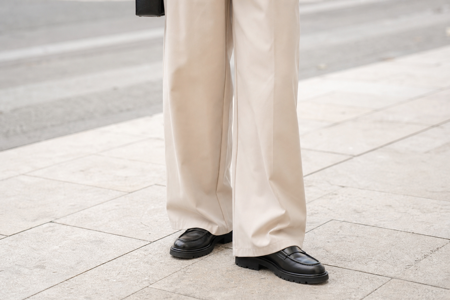 Femme portant un pantalon large fluide et des mocassins à semelle épaisse, cadrage sur le bas de la silhouette